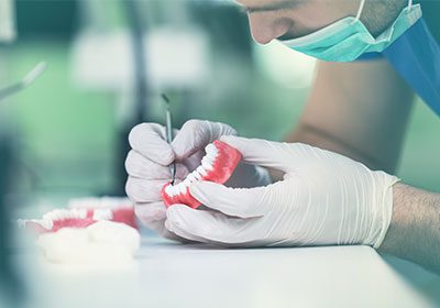 dentist inspecting false teeth dentist inspecting false teeth